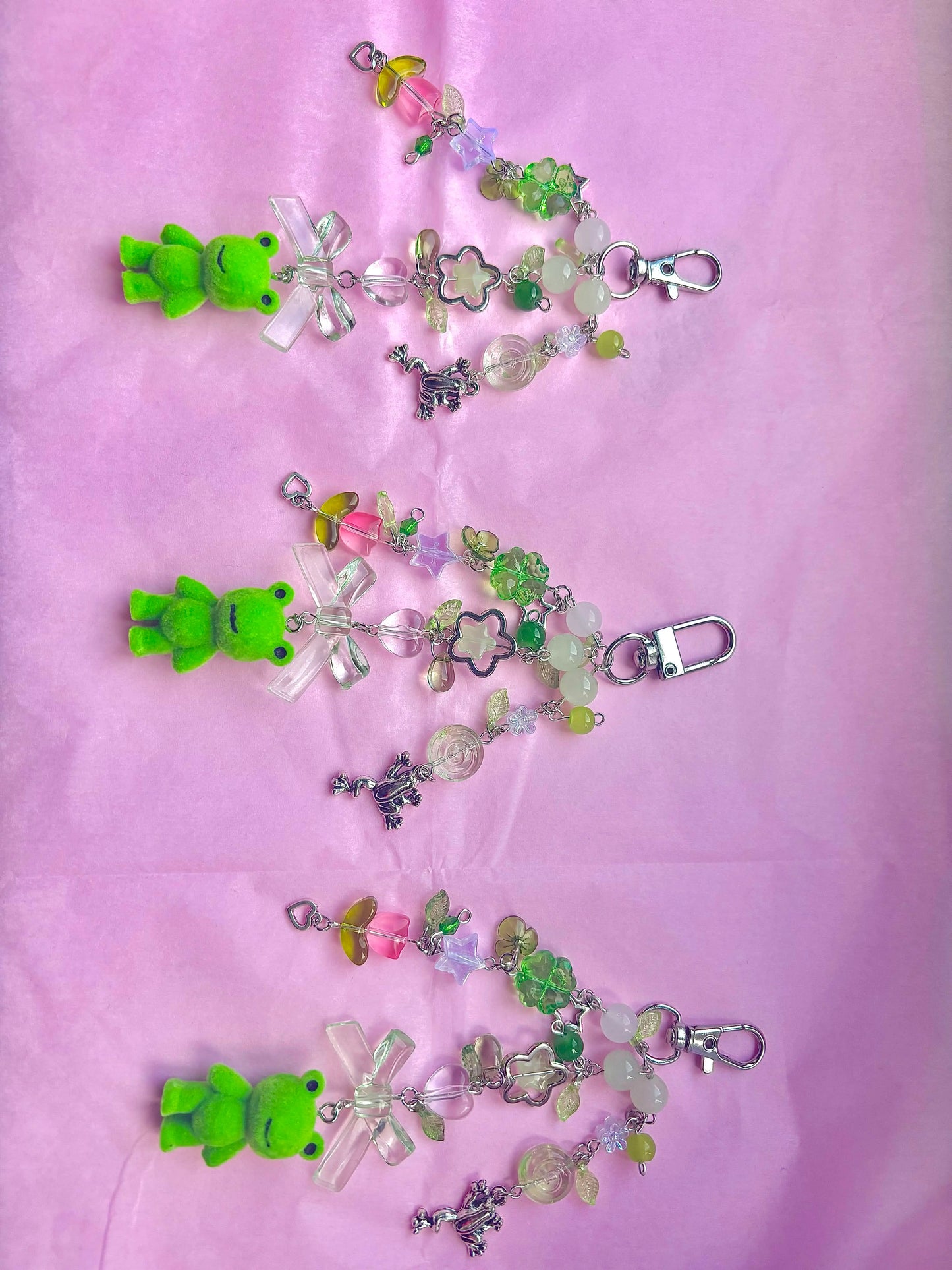 Colorful keychains with green bows on a pink background